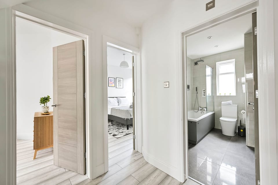 Bright hallway connecting bedrooms with a sleek modern bathroom