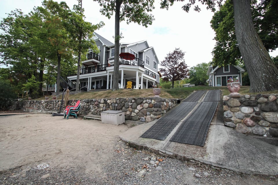 Beautifully landscaped property with sandy beach on the water’s edge.