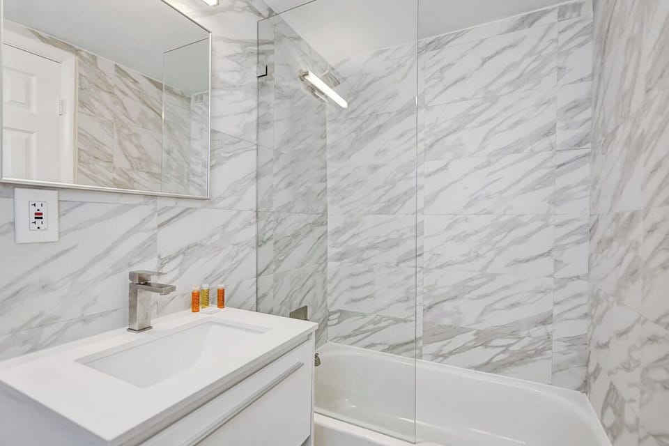 Indulge in a spa-like shower surrounded by elegant stone-look walls.