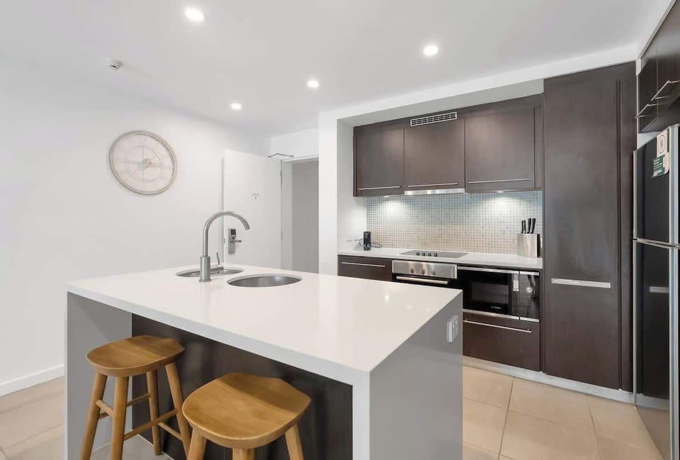 The kitchen blends dark cabinetry and smooth stone finishes with modern appliances, offering everything you need for relaxed, home-style cooking.