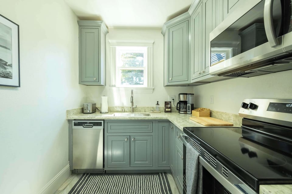 This bright kitchen corner features stainless steel appliances, ample cabinetry, and natural light for a fresh and functional cooking space