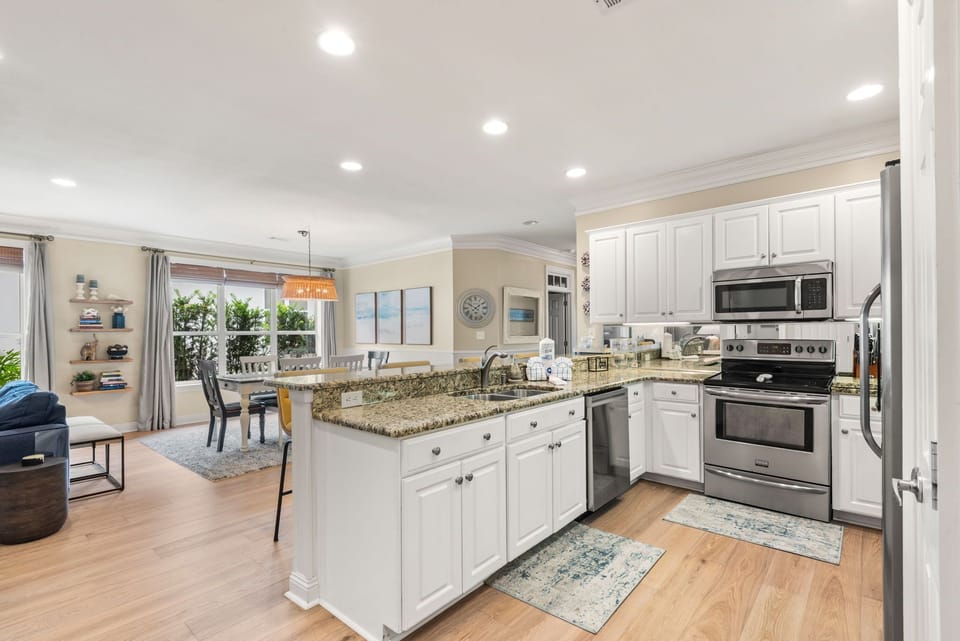 The bright, open-concept kitchen flows seamlessly into the dining and living spaces, perfect for gathering and creating memories.