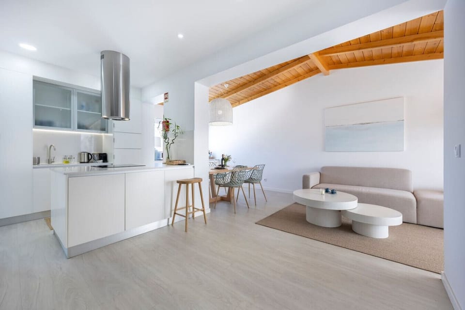 Spacious modernly furnished living room with view of kitchen and dining area.