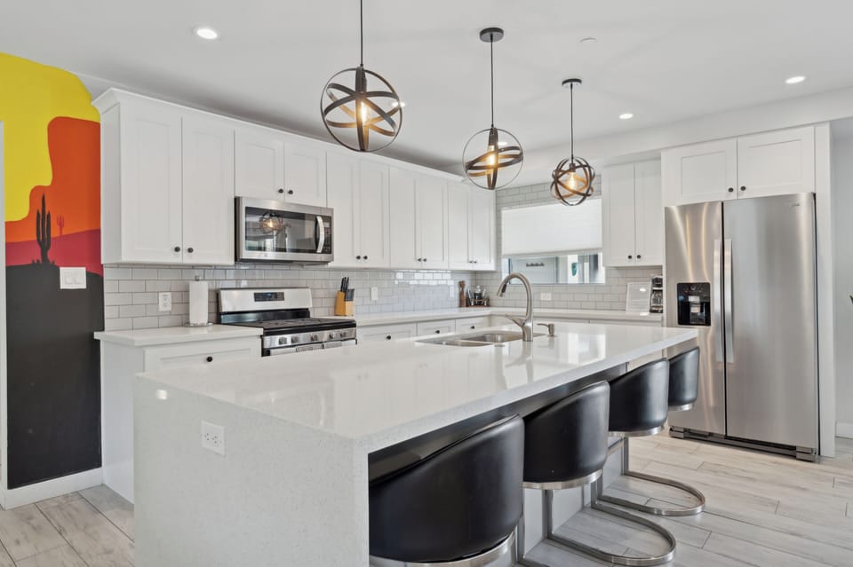 Modern kitchen with island and stainless steel appliances.
