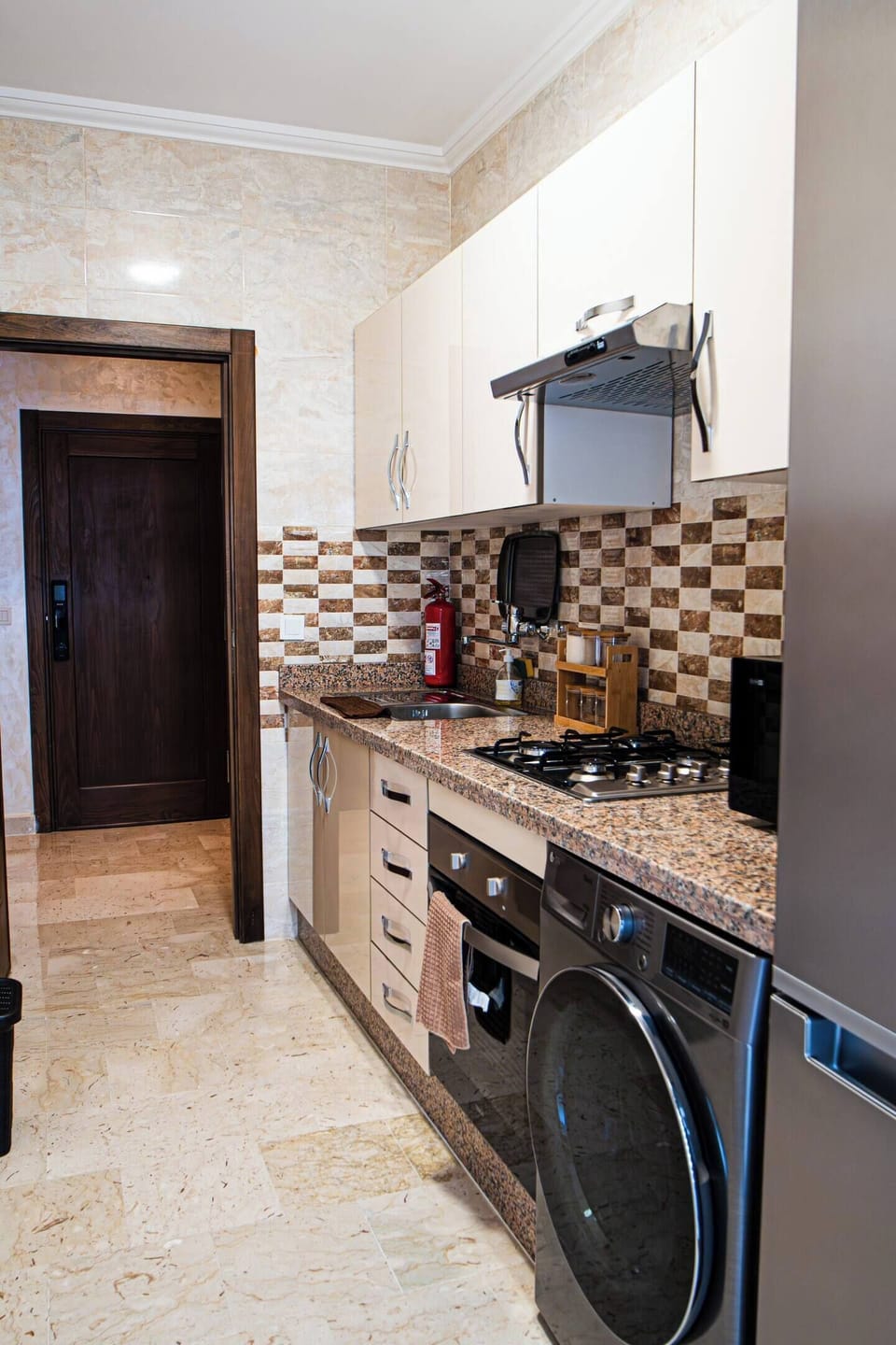 Kitchen equipped with a washing machine, oven, and all necessary safety items for a convenient and secure stay.
