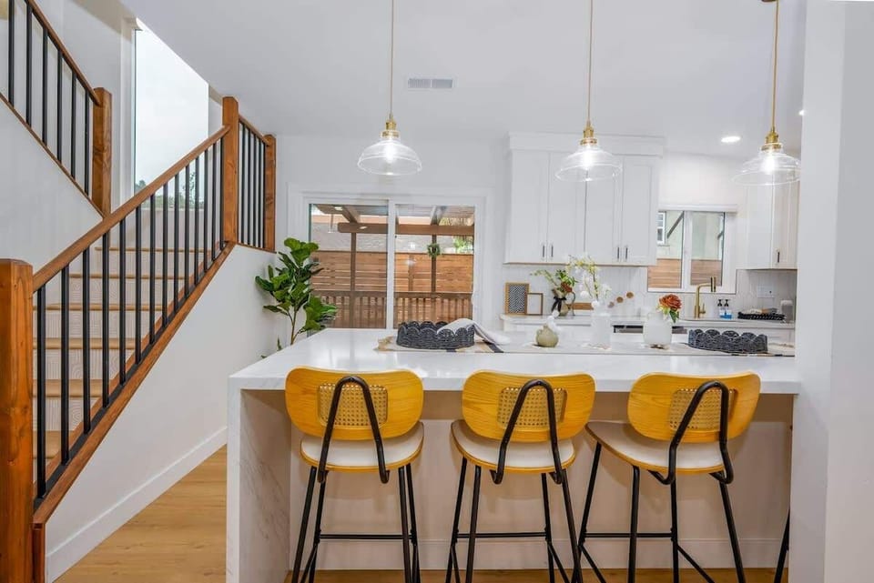Exposed wood staircase, with hand painted live metal art. Gorgeous bar top with easy access to the large patio area and driveway. The best part about this property is being able to escape while staying less than a mile from downtown!!