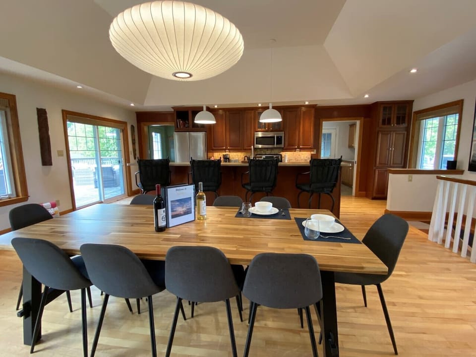 Large dining table in open concept living/dining/kitchen area. Seats up to 10