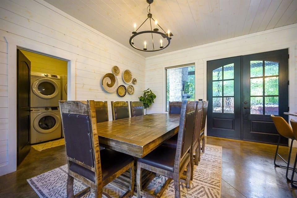 Around our wooden table, lit by a cozy chandelier, share stories and laughter after a day in nature.