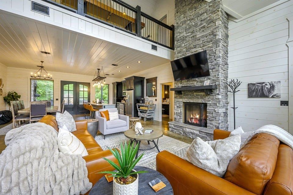 Kick back by the fire in a plush leather sectional as the vaulted ceilings of our Cozy White Cabin loft high above