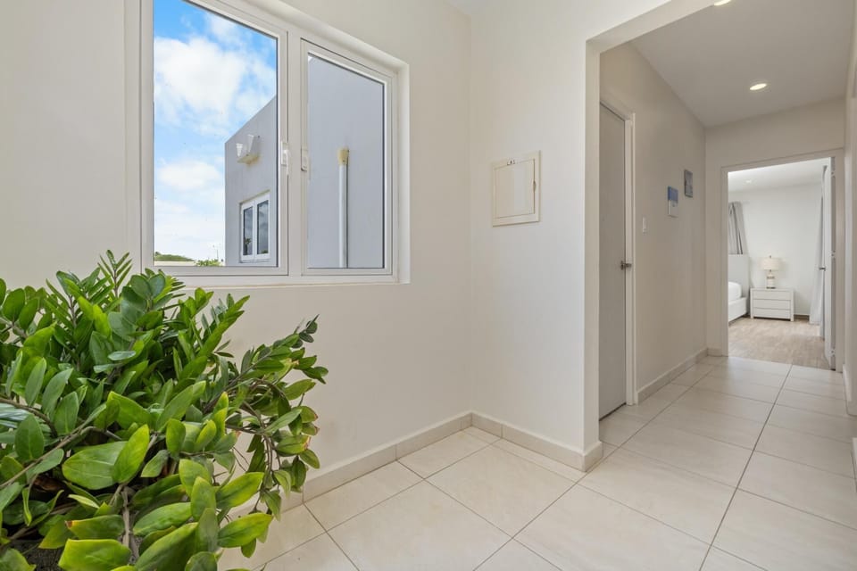 Natural light fills this upstairs hallway, complemented by greenery for a refreshing touch.