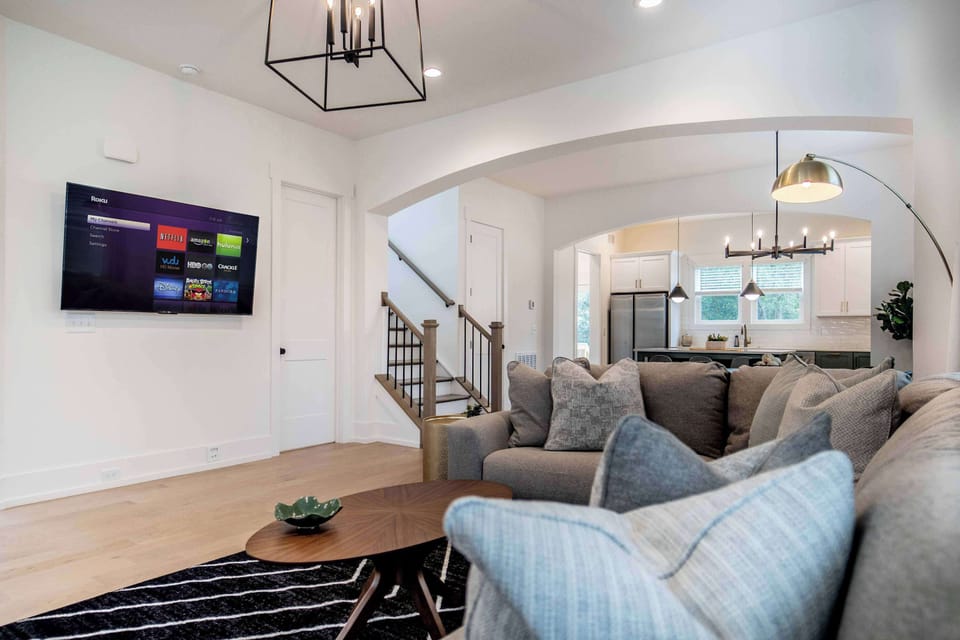 When you enter the house, you are greeted by an expansive living room with a large sectional couch and seating area as well as smart TV, perfect for movie nights or catching the big game.