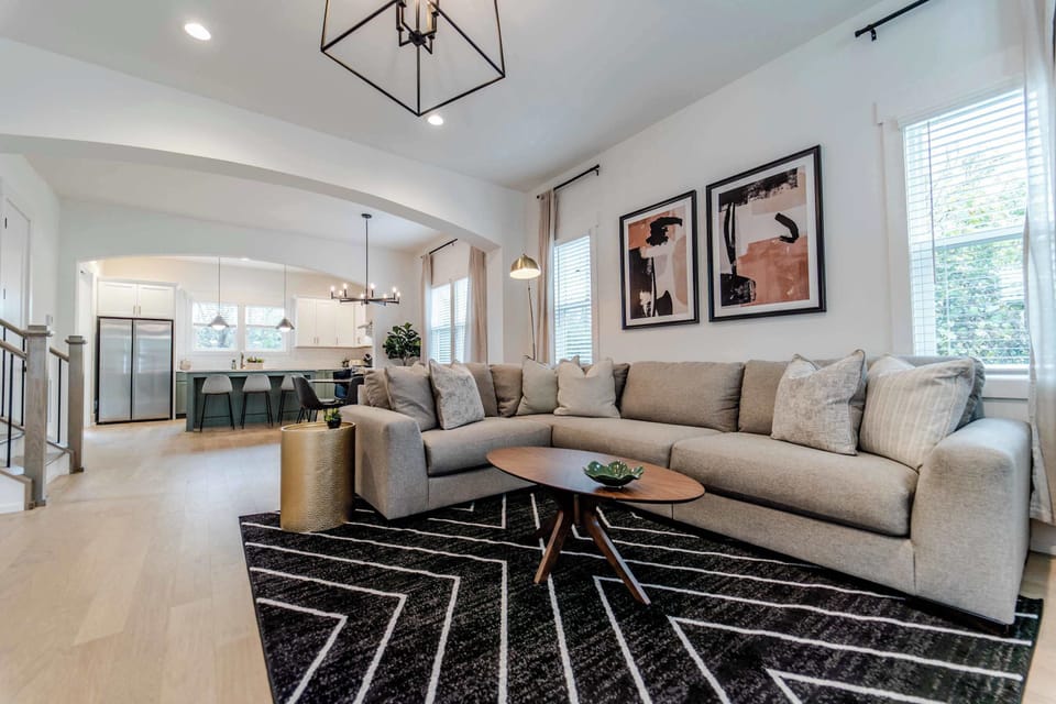 When you enter the house, you are greeted by an expansive living room with a large sectional couch and seating area as well as smart TV, perfect for movie nights or catching the big game.