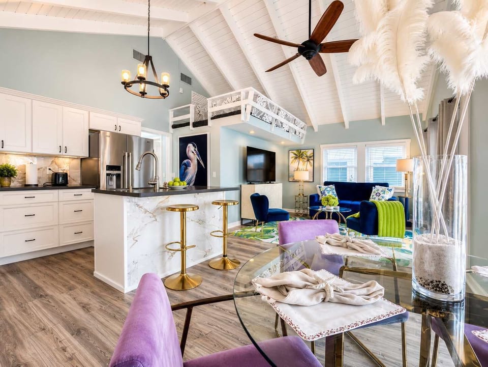 Sophisticated open-concept design with soaring ceilings, a stunning quartz kitchen island, and beautifully curated coastal décor — creating a bright, expansive space perfect for refined relaxation and entertaining.