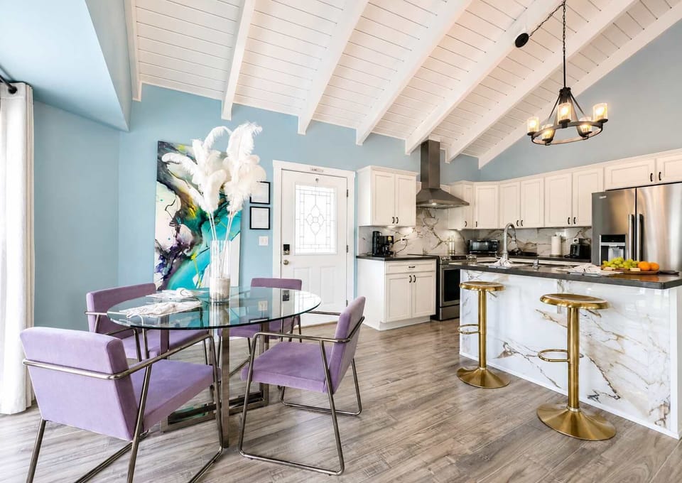 Elegant coastal dining space with designer seating and a seamless flow into the stunning quartz kitchen with chic bar stools — a sophisticated yet relaxed setting for sunset dinners and effortless entertaining.