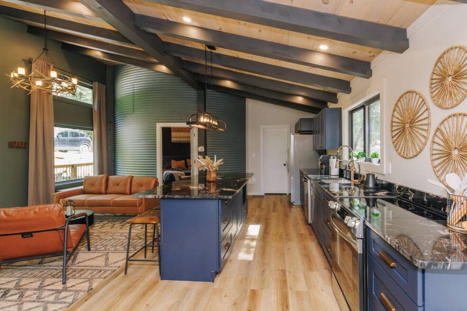 Picture evenings gathered here—dinner sizzling on the stove, laughter echoing under vaulted beams, and the silo wall catching the glow of warm lights. From sunrise coffee to late-night chats, this kitchen and living space is the heart of your stay.