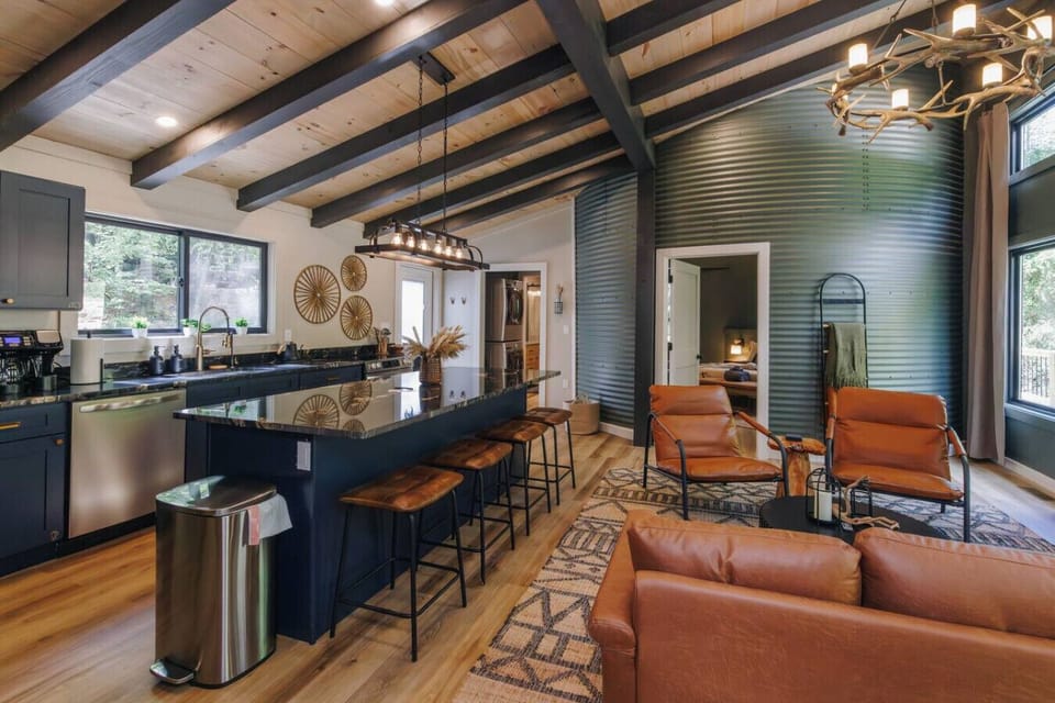 Imagine cooking breakfast in this stylish kitchen, sunlight streaming across the island while friends gather at the bar. The vaulted wood ceiling and silo wall create a one-of-a-kind space where laughter and conversation flow as easily as the coffee.