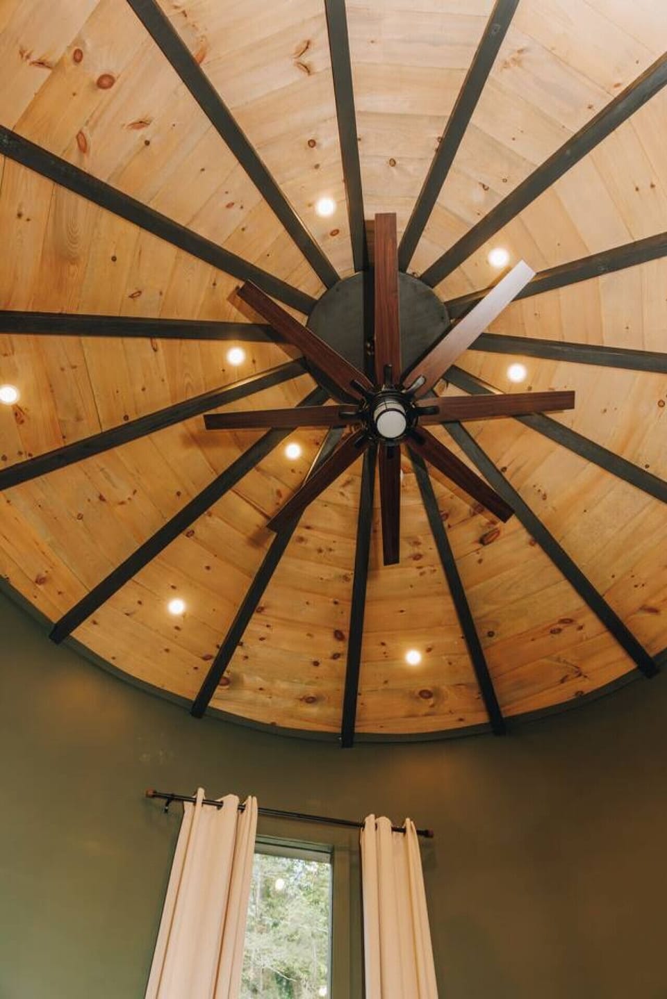 Look up and you’ll see the silo’s crown—a ceiling of warm pine beams fanning out around a statement fan. Simple, striking, and one of those details that reminds you this cabin was crafted to be as unique as the forest outside.