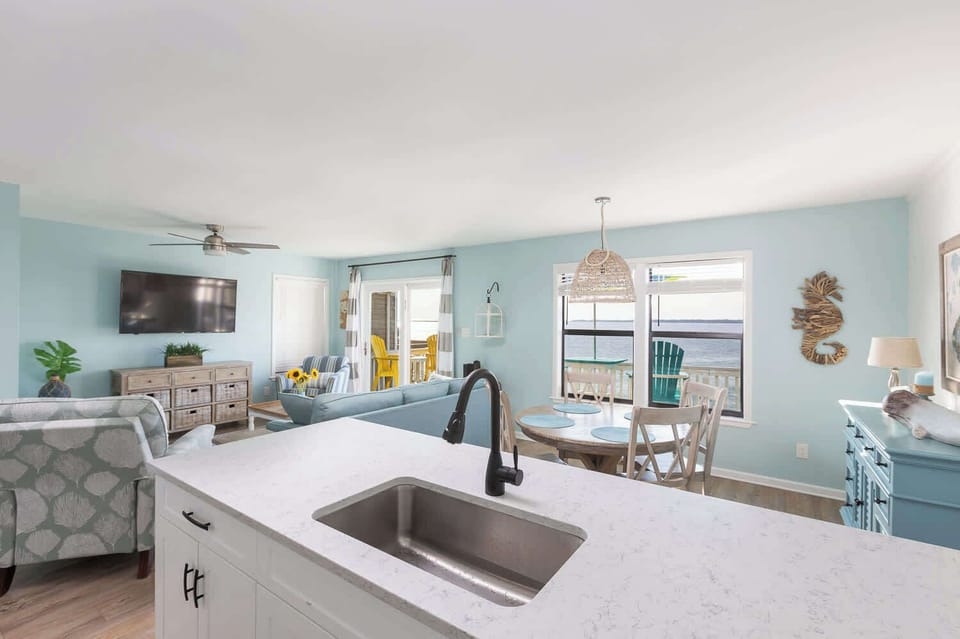 Bright dining, kitchen, and living space on the upper level with easy deck access and open flow (main dining seats 4 and spacious countertop w/ bar seating for 4)