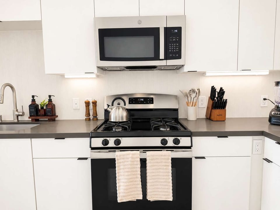 Experience extended comfort with a fully equipped kitchen featuring a coffee machine, stovetop, and microwave—everything you need for a seamless long-term stay.