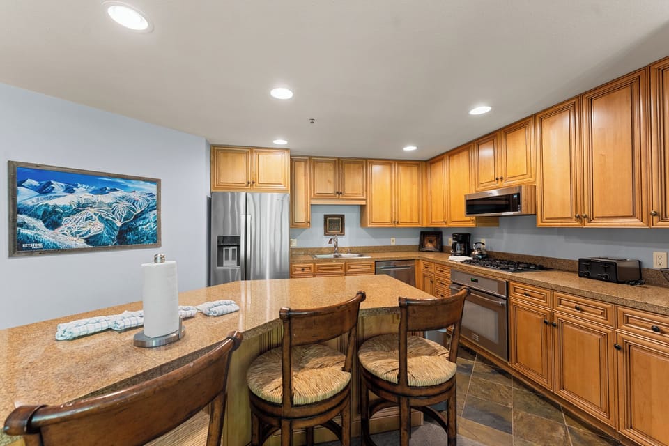 Your fully-equipped kitchen features warm wood cabinetry, granite countertops, and modern appliances for memorable mountain getaway meals.