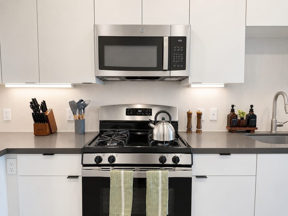 Experience extended comfort with a fully equipped kitchen featuring a blender, toaster, coffee machine, stovetop, and microwave—everything you need for a seamless long-term stay