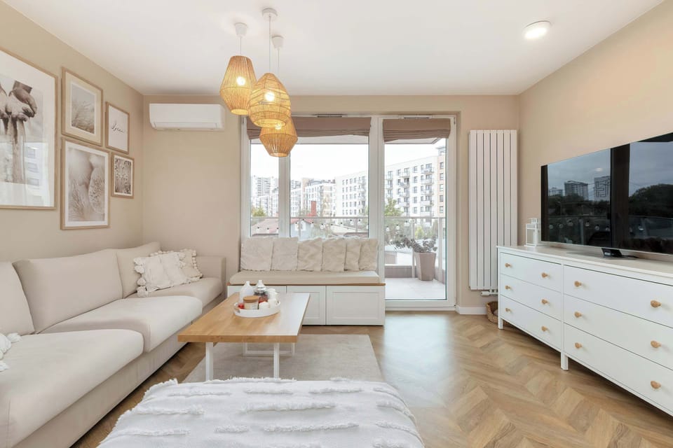 The living area features a sleek coffee table and a flat-screen television.