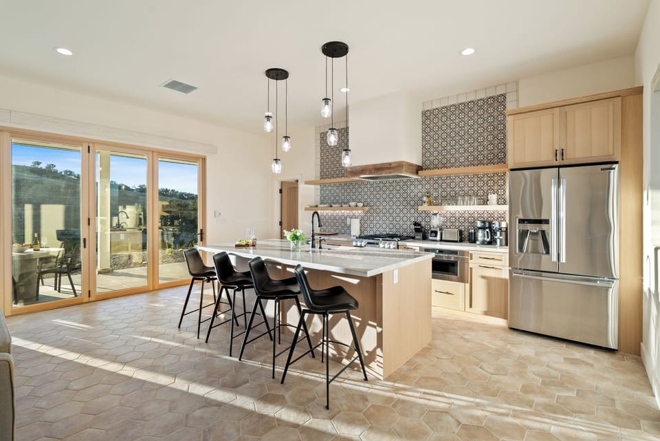 Fully Stocked Kitchen with Stainless Steel Appliance and Bar Seating.