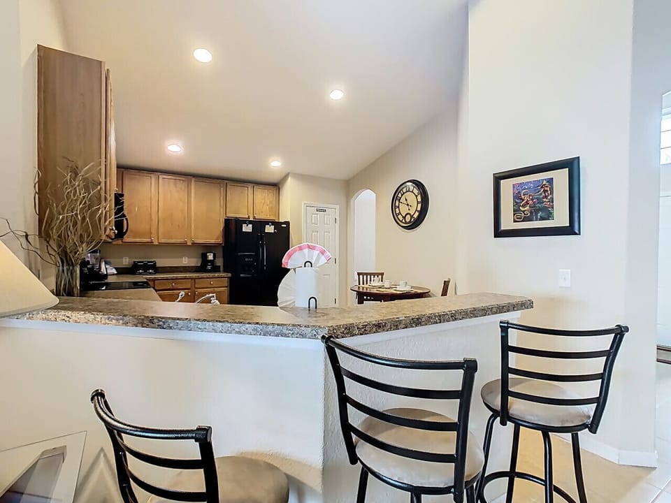 The kitchen features a spacious breakfast bar, perfect for quick bites and conversation.