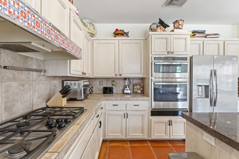 Kitchen detail w/ double ovens, gas range & generous counter space