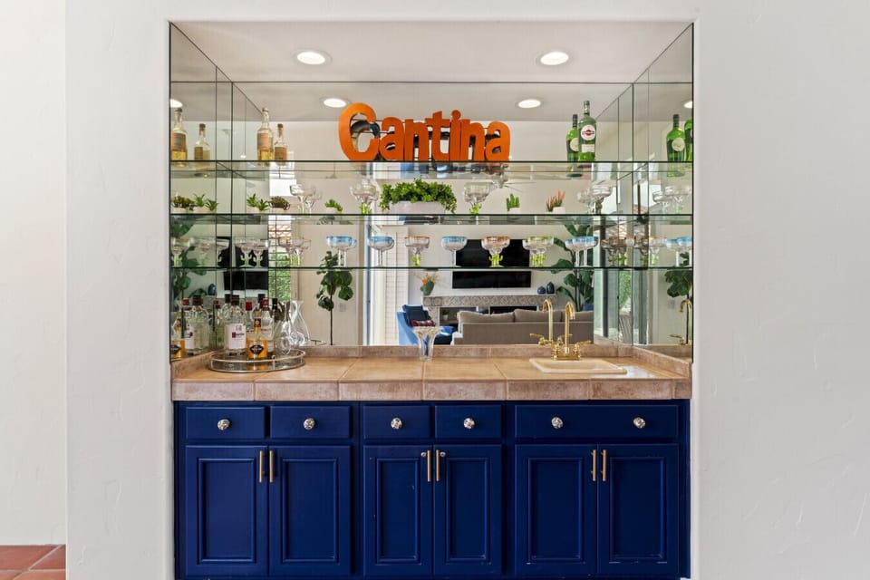 Stylish cantina bar w/ mirrored backsplash & glass shelving for display