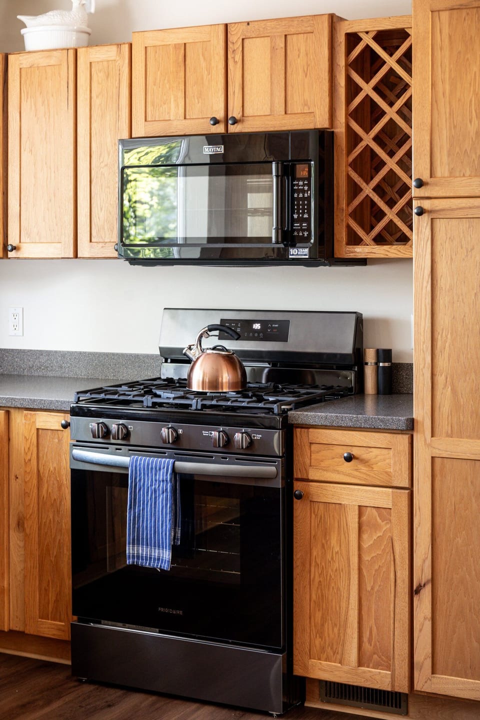 Gas range w/ spacious counters & wood cabinetry for easy home-cooked meals