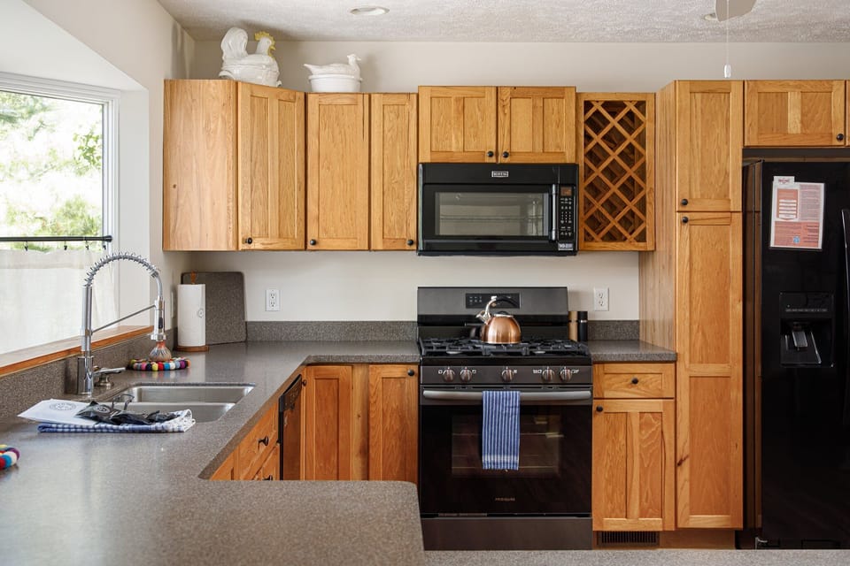 Bright kitchen w/ wood cabinets, black appliances & plenty of counter space