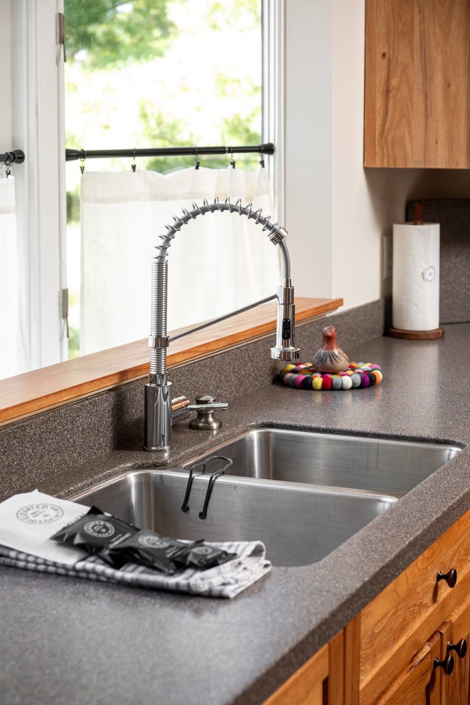 Kitchen sink w/ sleek faucet & window views bringing in natural light