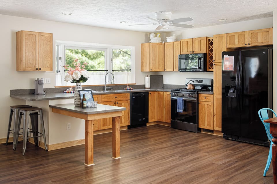 Fully equipped kitchen w/ wood cabinets, island seating & plenty of counter space