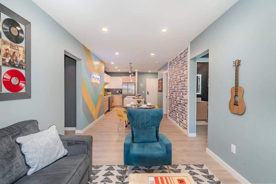 Living room with cozy seating, smart TV, and music-inspired décor featuring country album art.