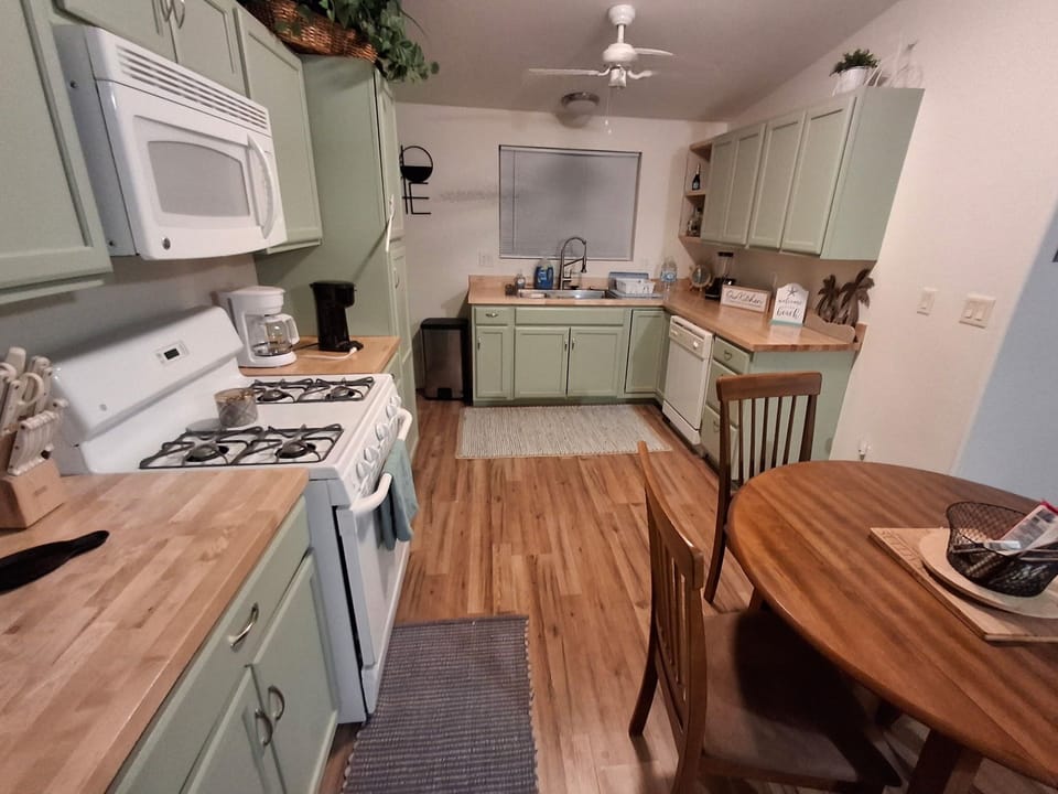 spacious kitchen  with pots, pans, dishes  utensils coffee pot, blender and more