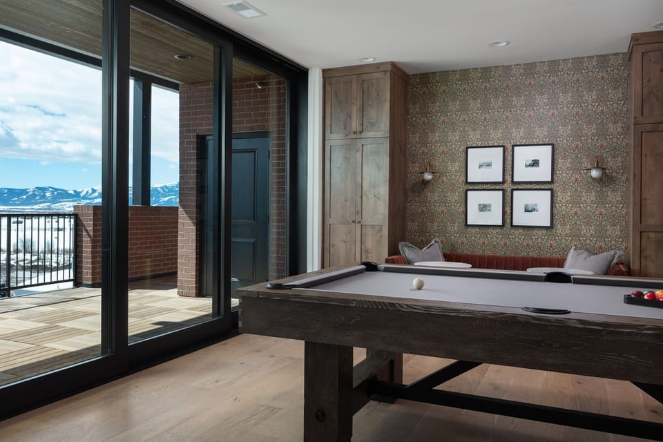 Grand (Penthouse) - Chic game area with a modern pool table, cozy loveseat, and direct access to the rooftop deck.
