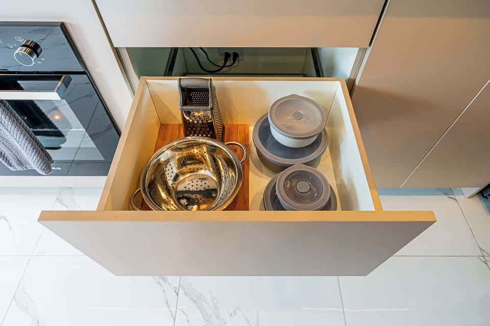 Drawer interior, showing organized bowls, cups, and glasses.