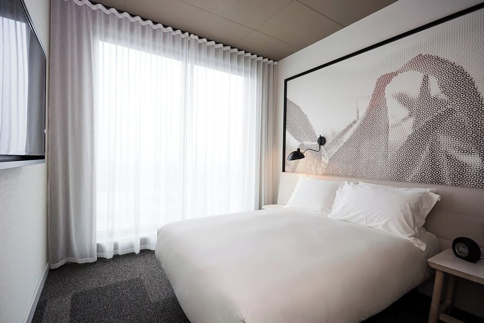 Unwind in bright, airy comfort beside soft floor-to-ceiling drapes.