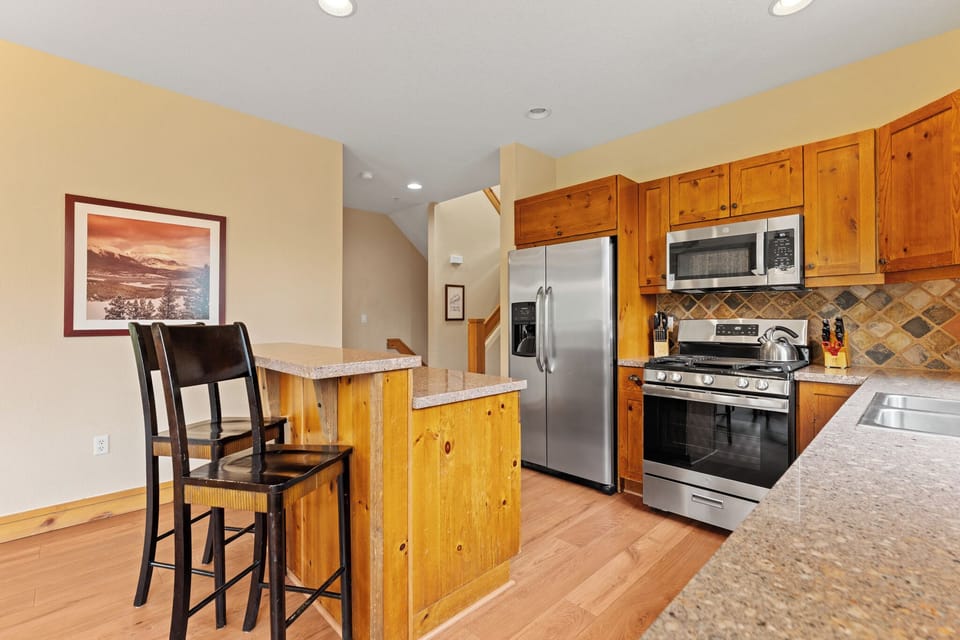 Your fully equipped kitchen offers granite countertops, stainless steel appliances, and a cozy breakfast bar perfect for morning coffee or casual meals together.