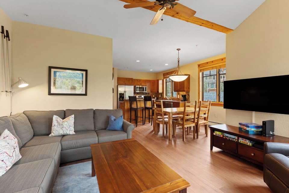 Unwind in your open-concept haven with plush seating, natural wood accents, a full kitchen, and dining for six—perfect for relaxing evenings together after mountain adventures.