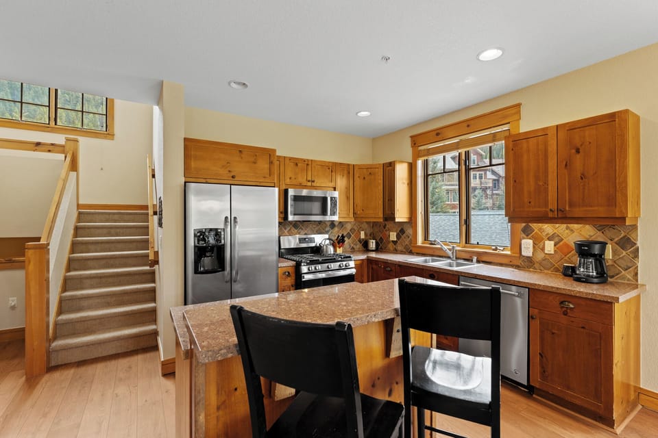 Your fully equipped kitchen with granite countertops and stainless appliances invites effortless meal prep. Natural light streams through the windows as you enjoy morning coffee at the island, ready to fuel your mountain adventures.