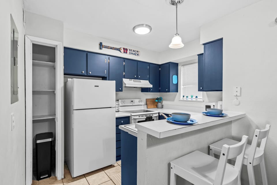 Kitchen equipped with pots, pans, utensils, dishes and a Keurig coffee maker