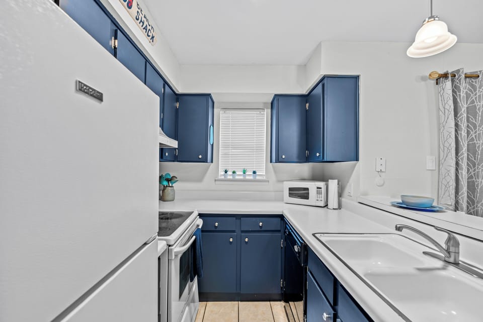 Kitchen equipped with pots, pans, utensils, dishes and a Keurig coffee maker 