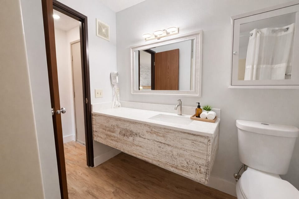 Updated bathroom area offering wood-textured finishes and ample lighting.