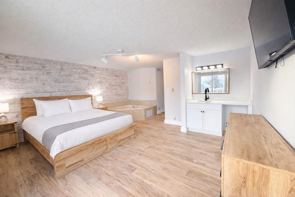 Spacious King Jacuzzi + Kitchette Suite with plush bedding, HDTV, and natural light.
