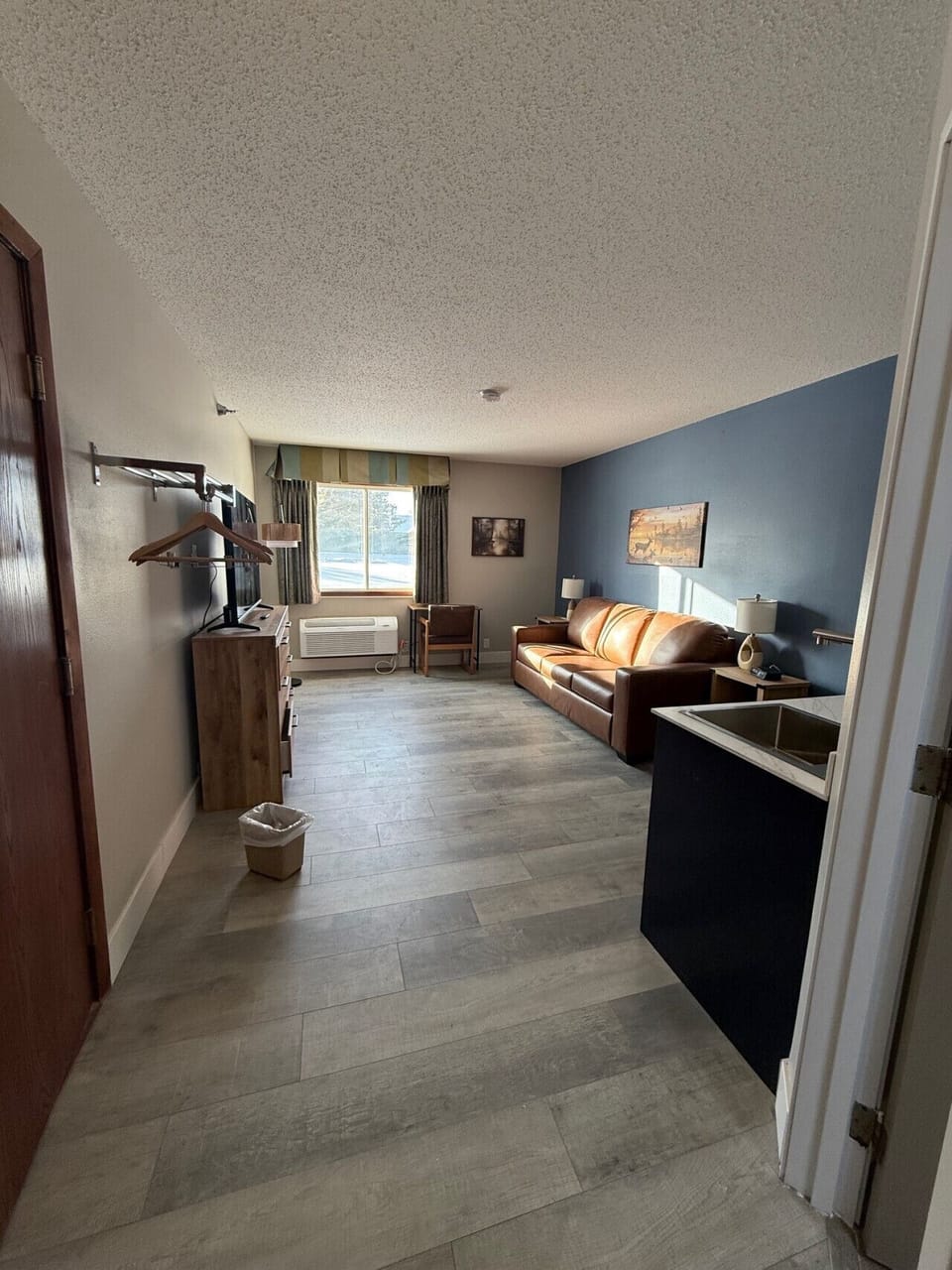 Modern guest lounge offering a leather sofa and workspace.