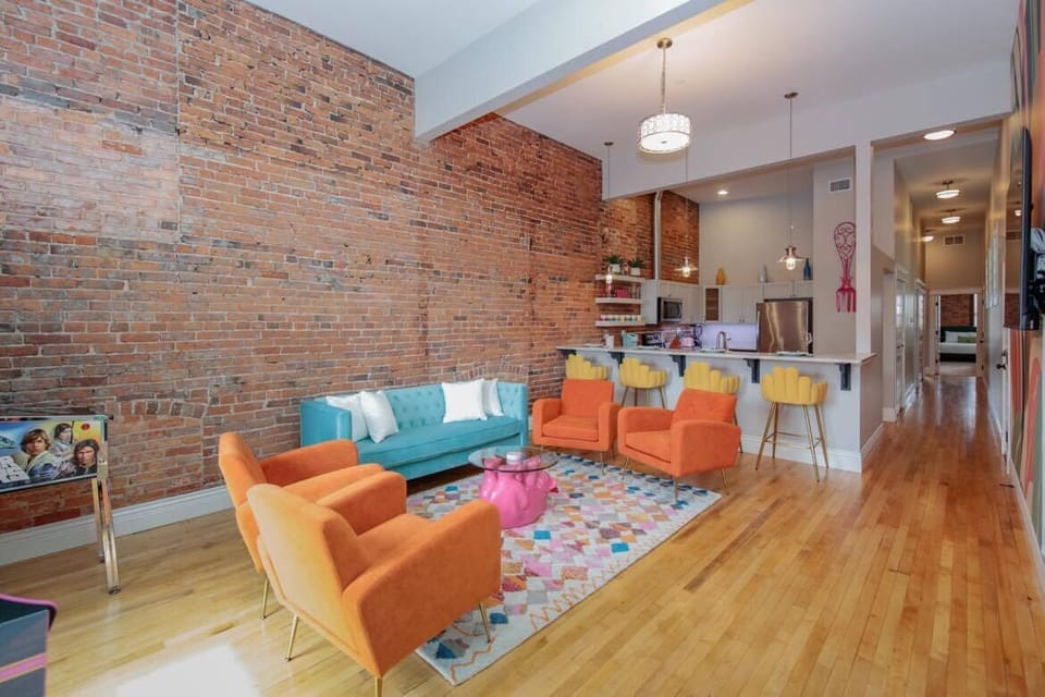 Enjoy the 13ft ceilings and exposed brick in this living space.