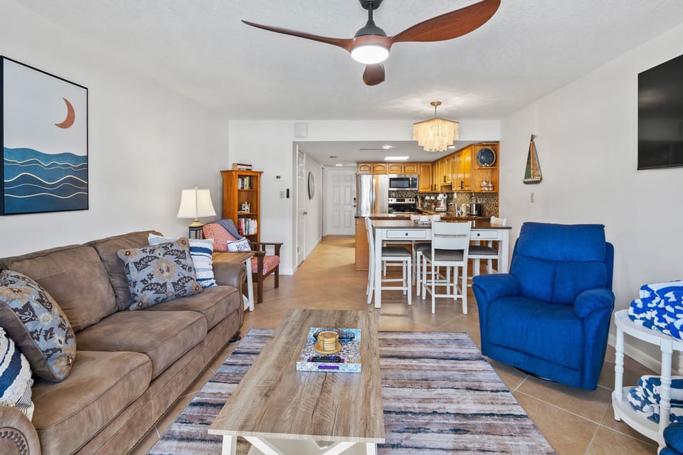 Enjoy a bright open-concept living area with beach-inspired décor, comfy seating, and a fully equipped kitchen—perfect for relaxing and entertaining during your seaside getaway.