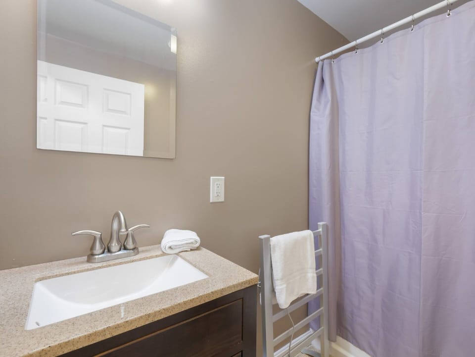 The vanity and curtained bathing area keep getting ready in one place.